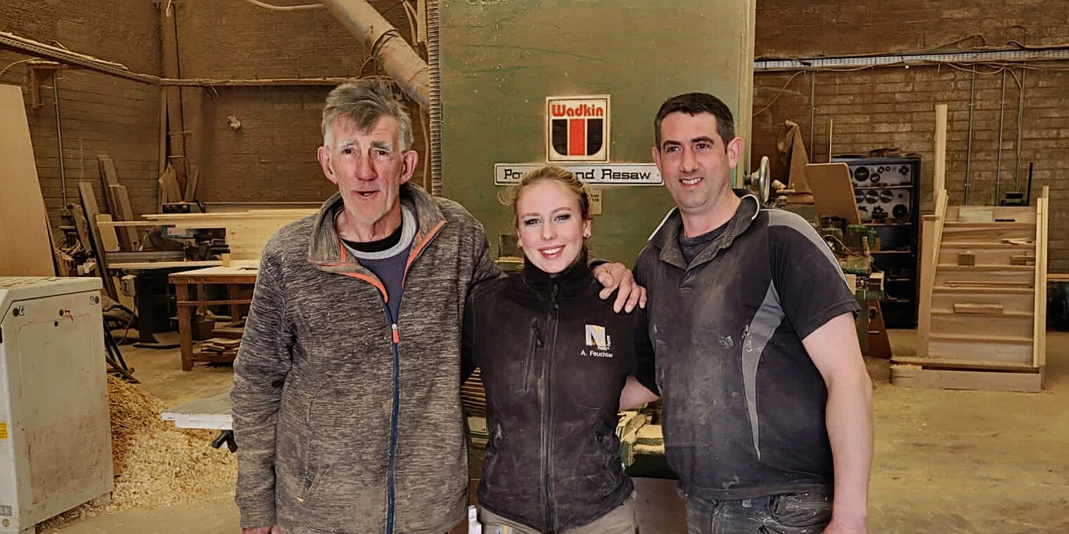 Schreiner-Azubi Alicia Fechter mit ihren beiden Chefs in Irland in der Werkstatt