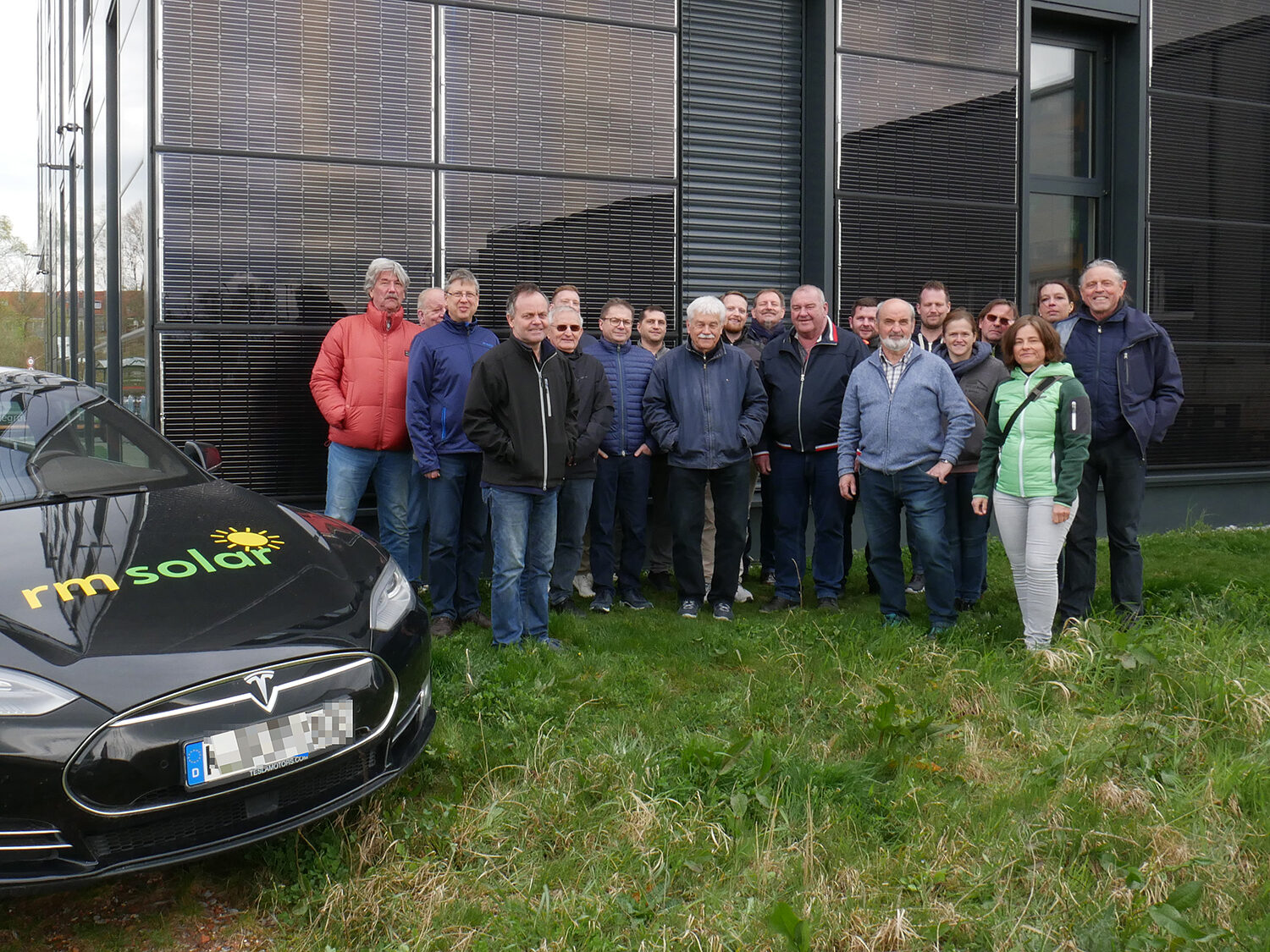 Die Exkursion der Handwerkskammer führte unter anderem zum Gebäude der rmsolar GmbH in Reichenau-Lindenbühl, das auf dem Dach und an großen Teilen der Fassade mit Photovoltaikmodulen bestückt ist. Die Anlage speist die Stromtankstellen für den Elektrofuhrpark, den Strom für Infrarotheizungen sowie die Brauchwasserwärmepumpe. Gruppenbild der Exkursionsteilnehmer vor dem Gebäude der rm solar in Reichenau-Lindenbühl.
